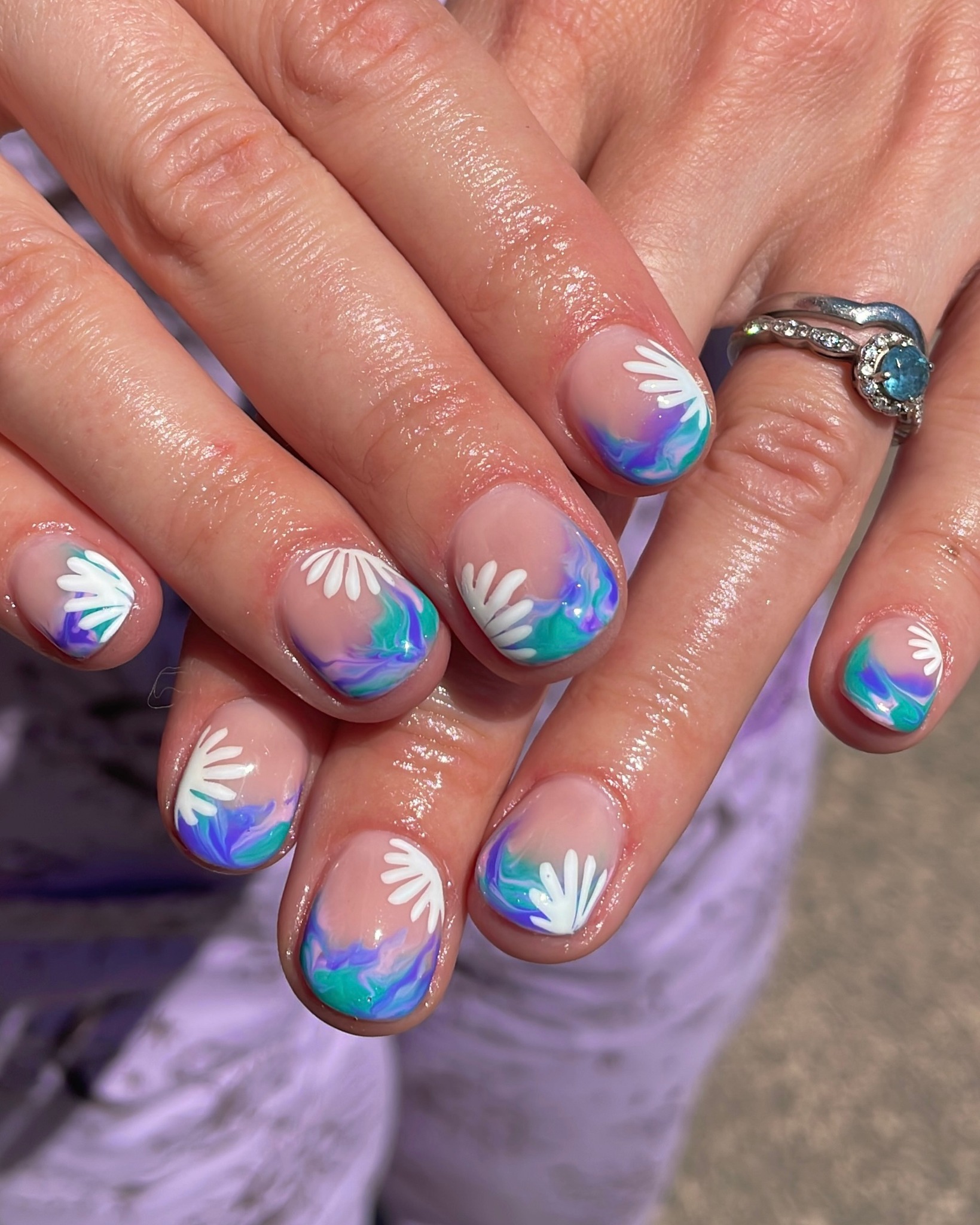 Nude nails with teal purple swirl French tips and white daisies