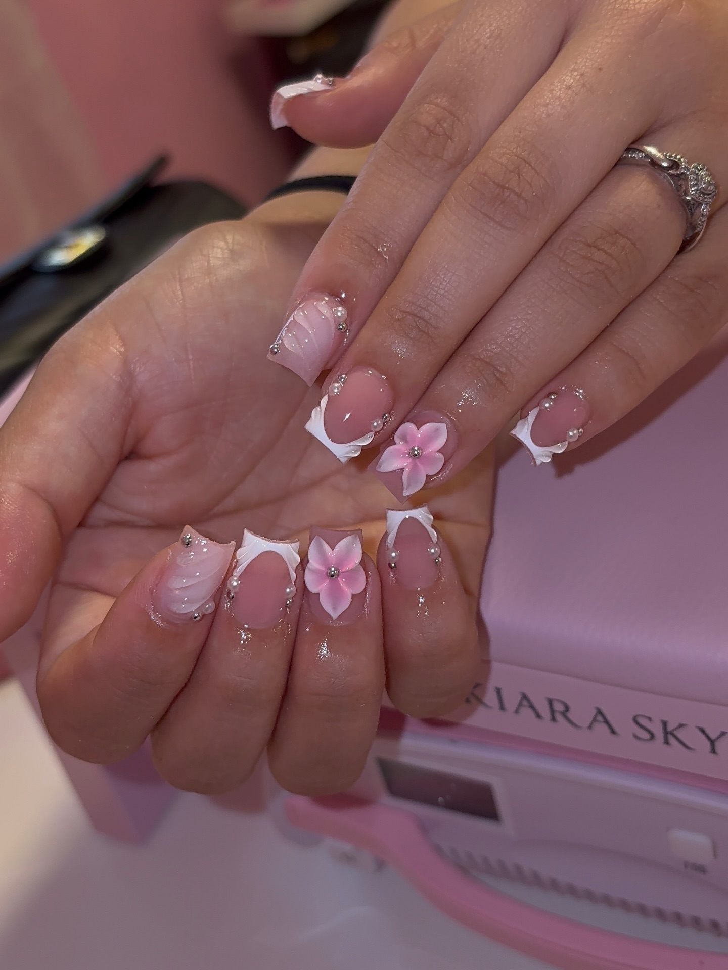 Sheer pink nails with 3D florals and pearl bead details