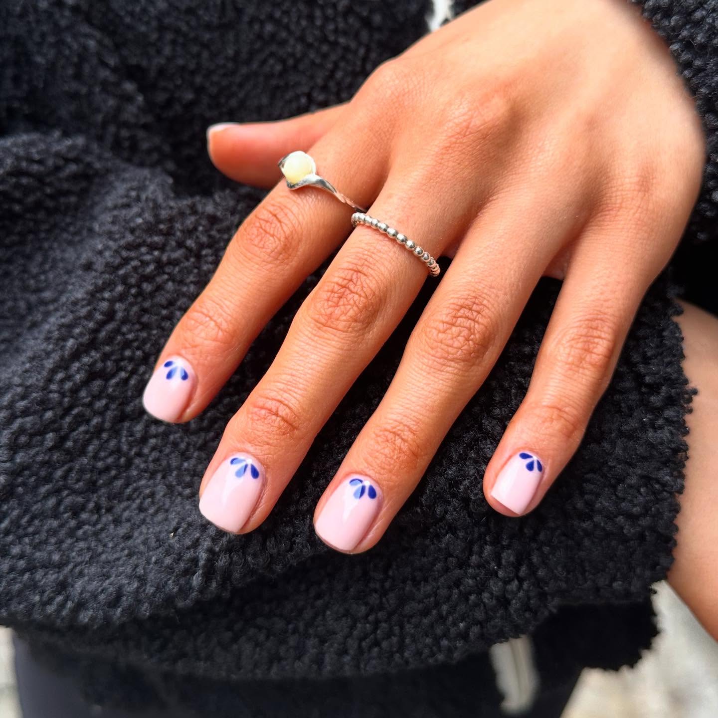 Soft pink nails with tiny navy petal accents