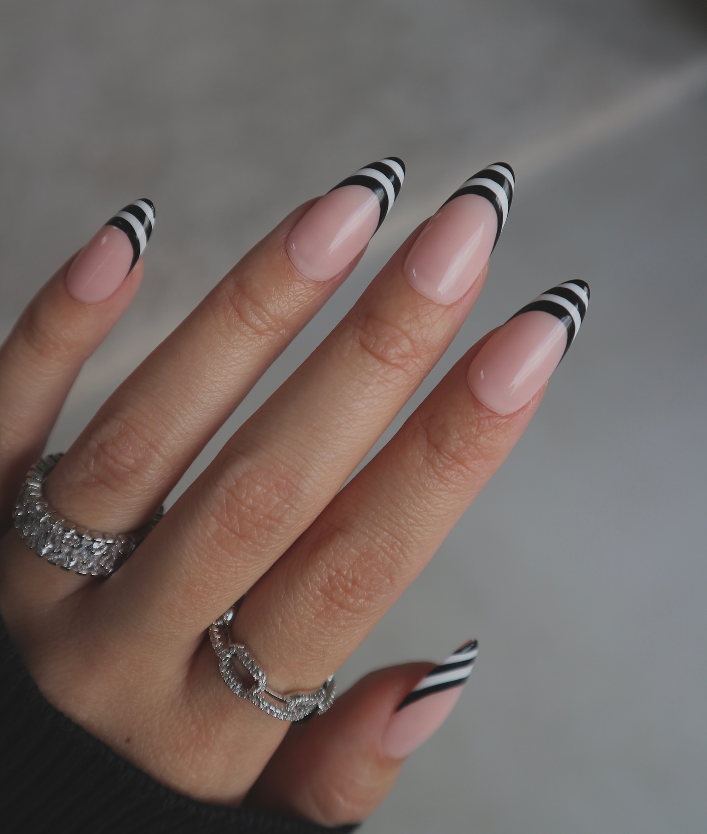 Long almond nails with black and white striped French tips