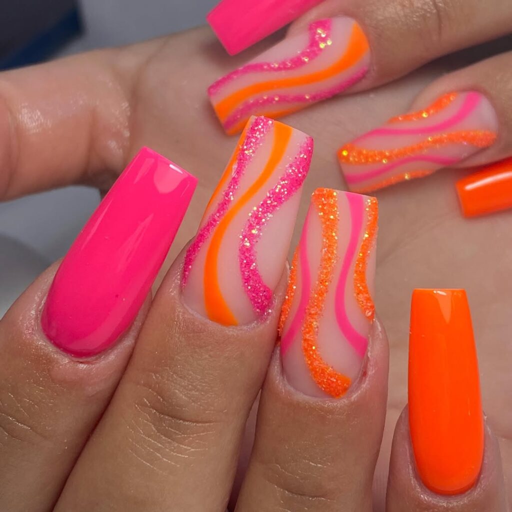 Long square acrylic nails featuring vibrant neon pink and orange swirls