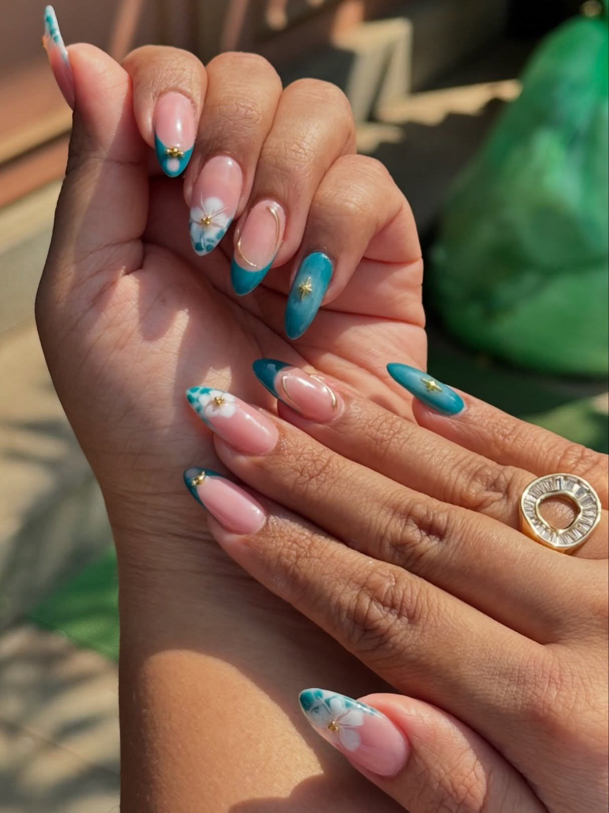 Teal French tip nails with white hibiscus and gold star beads