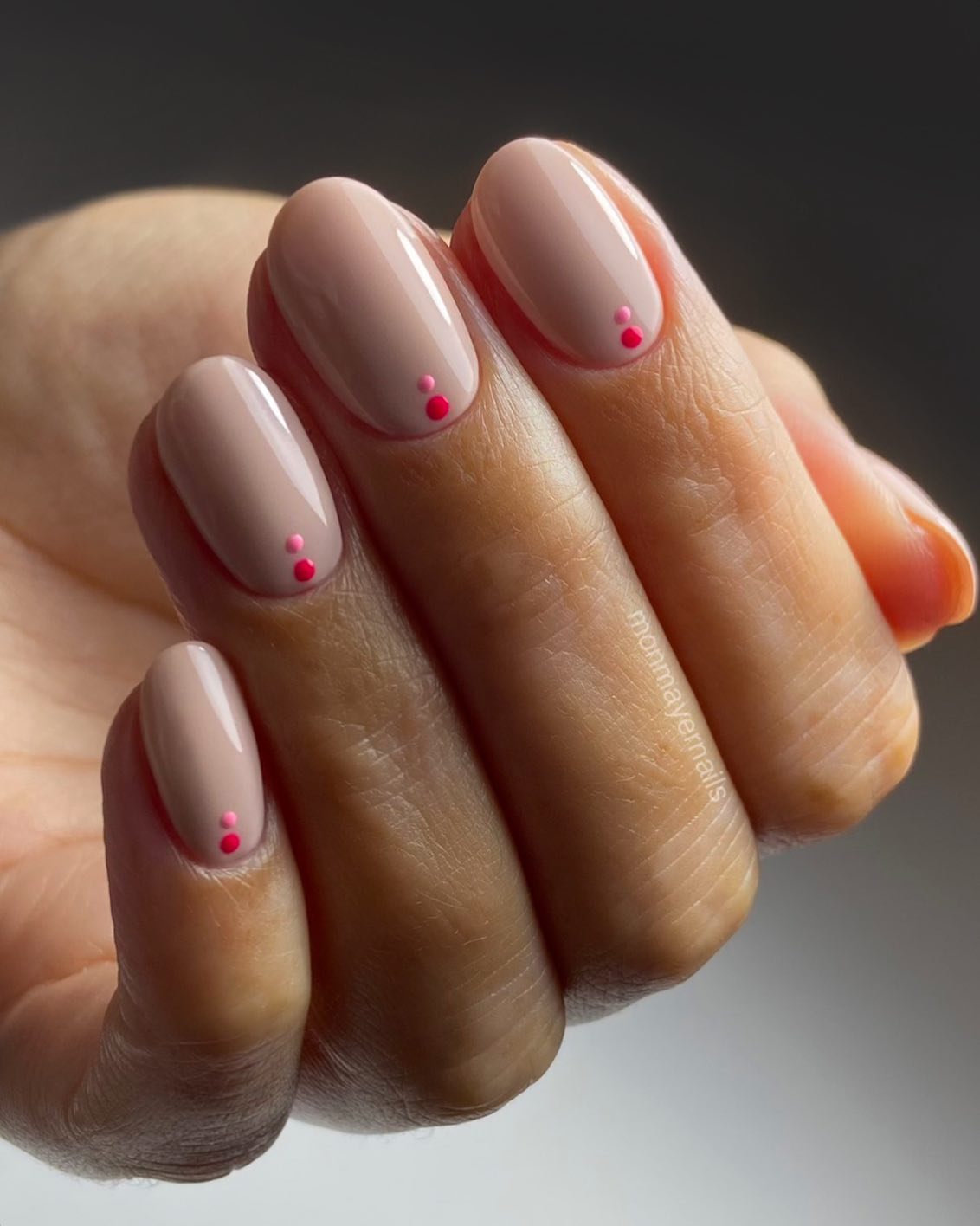 Warm nude oval nails with two tiny hot pink dot accents