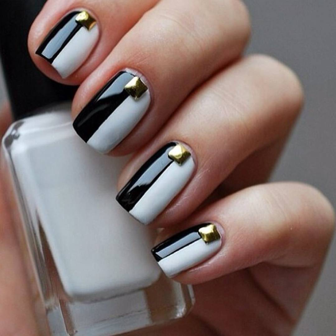 White and black geometric nails with gold pyramid studs
