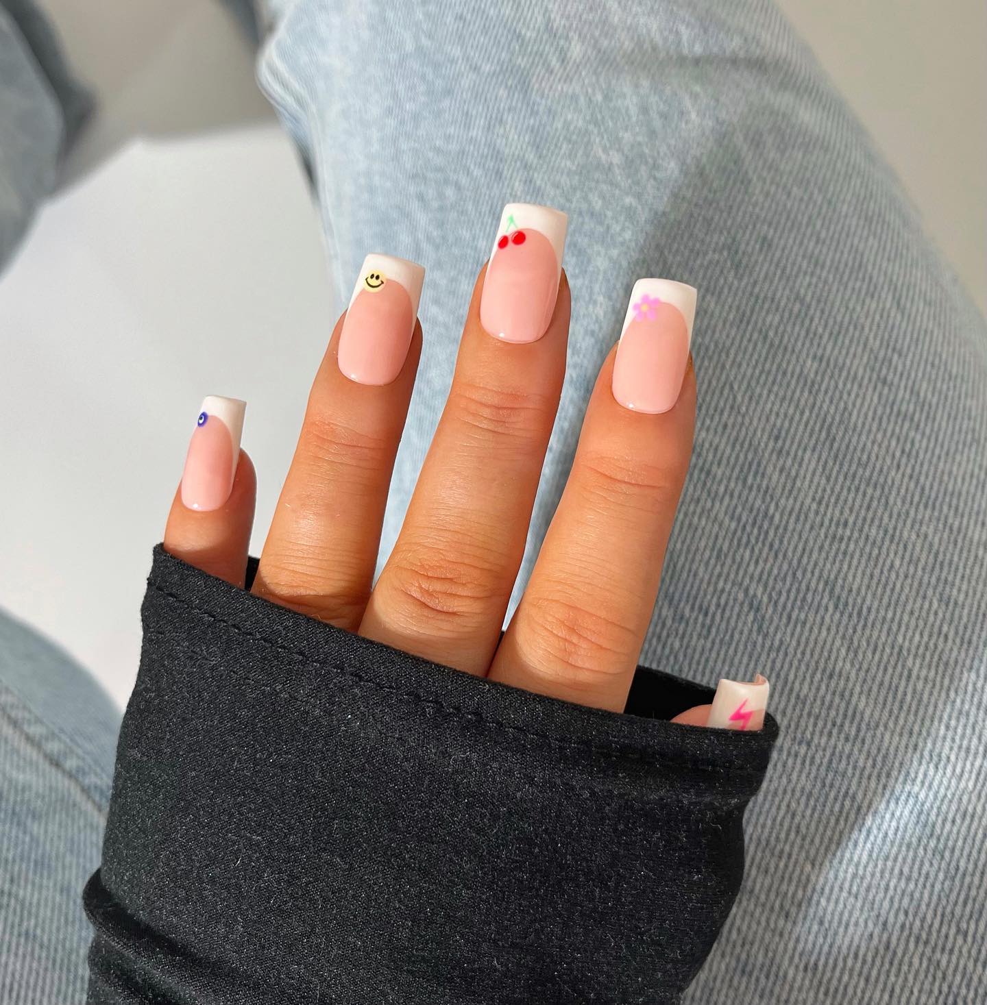White French tips with tiny painted cherry and smiley face icons