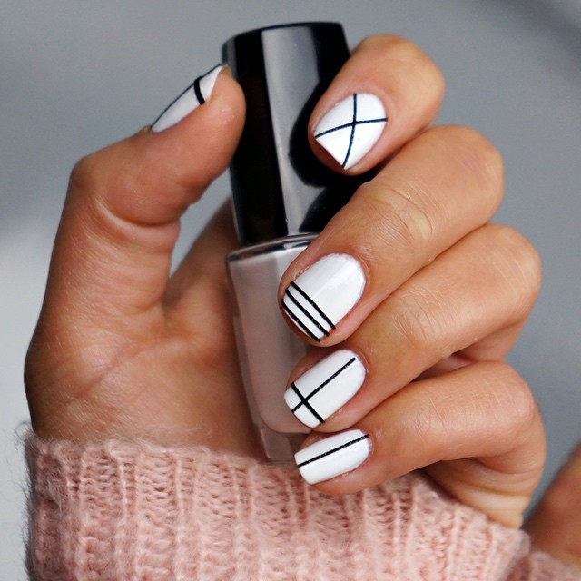 White nails with black geometric grid and cross line designs