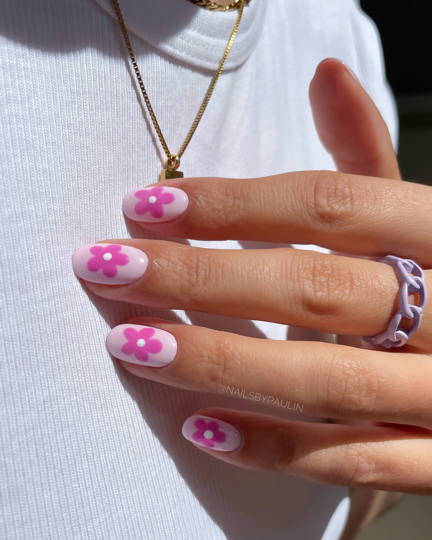 Short oval white nails with a single oversized hot pink retro daisy on each nail