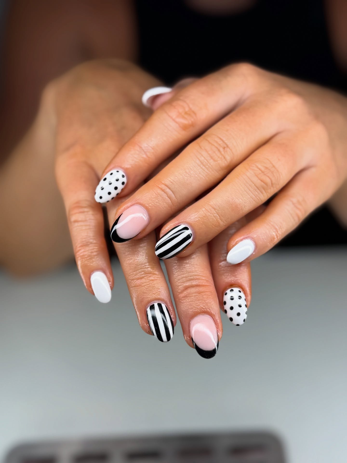 White nails with mixed polka dots and black stripes