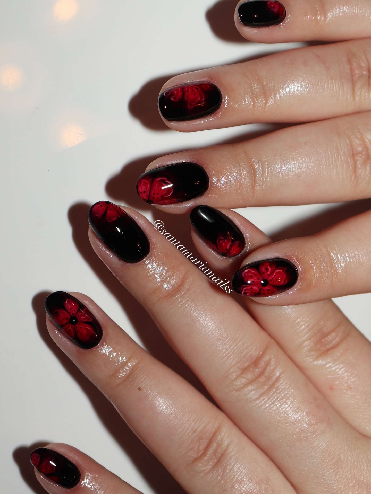 Short oval black nails with red rose and floral nail art on accent fingers