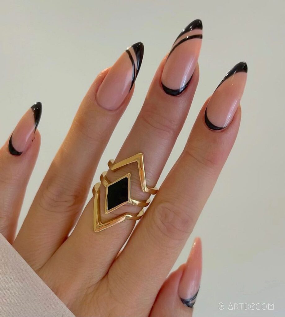 Long oval nails with black tips and a single diagonal black line across the nude base