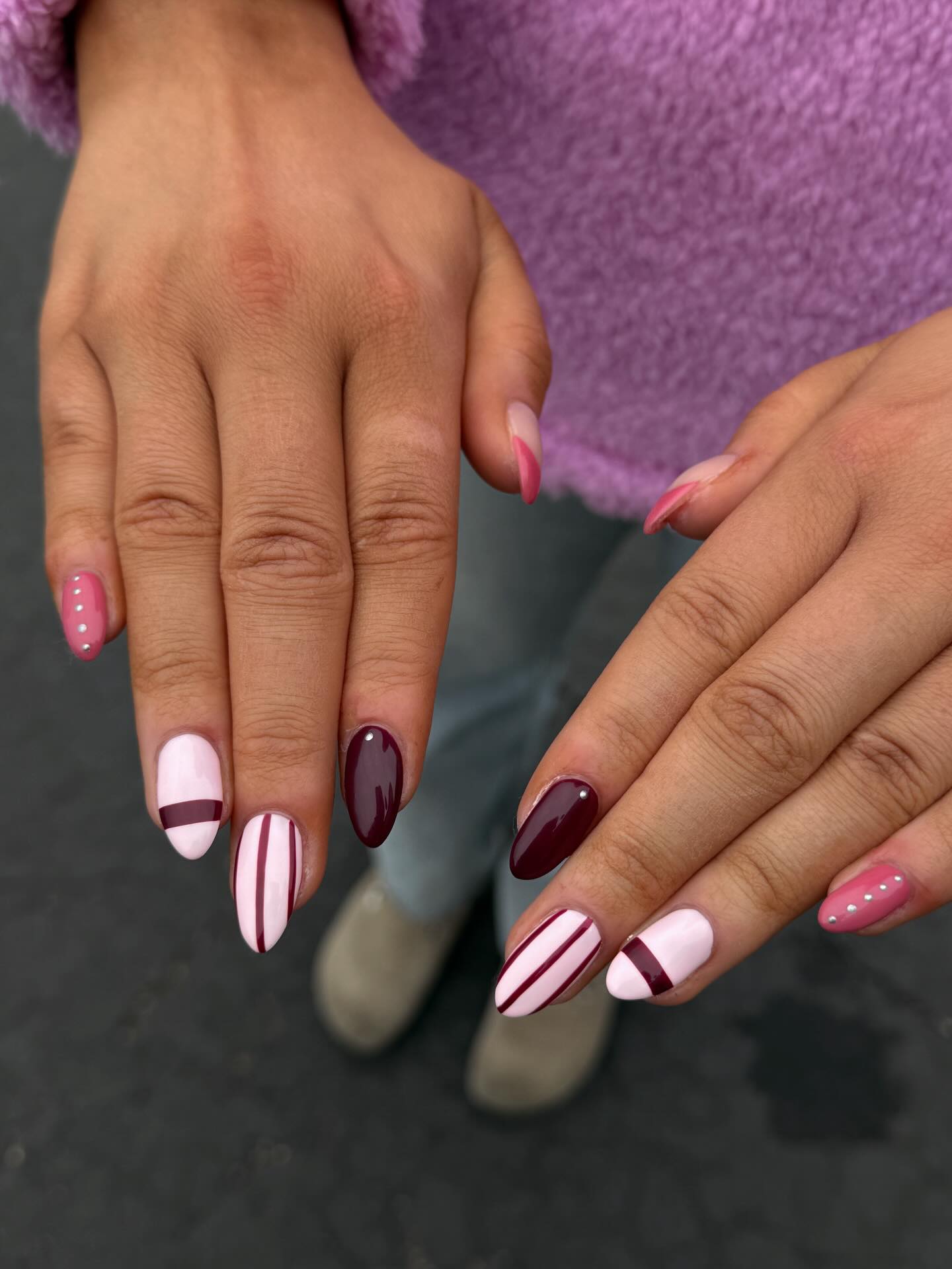 Burgundy and white stripe almond nails with pink pearl accents