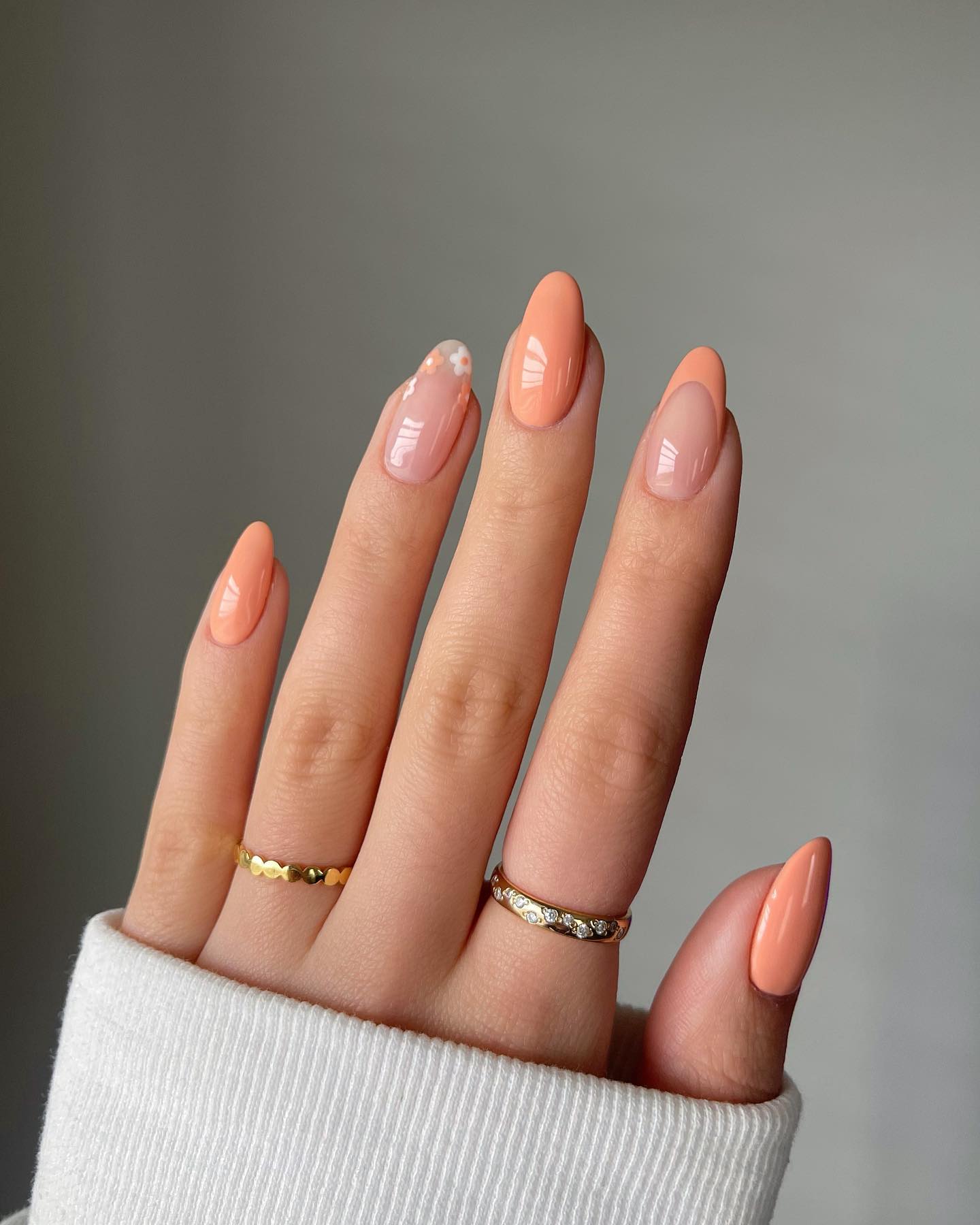 Glossy peach almond nails with a subtle aurora shimmer accent