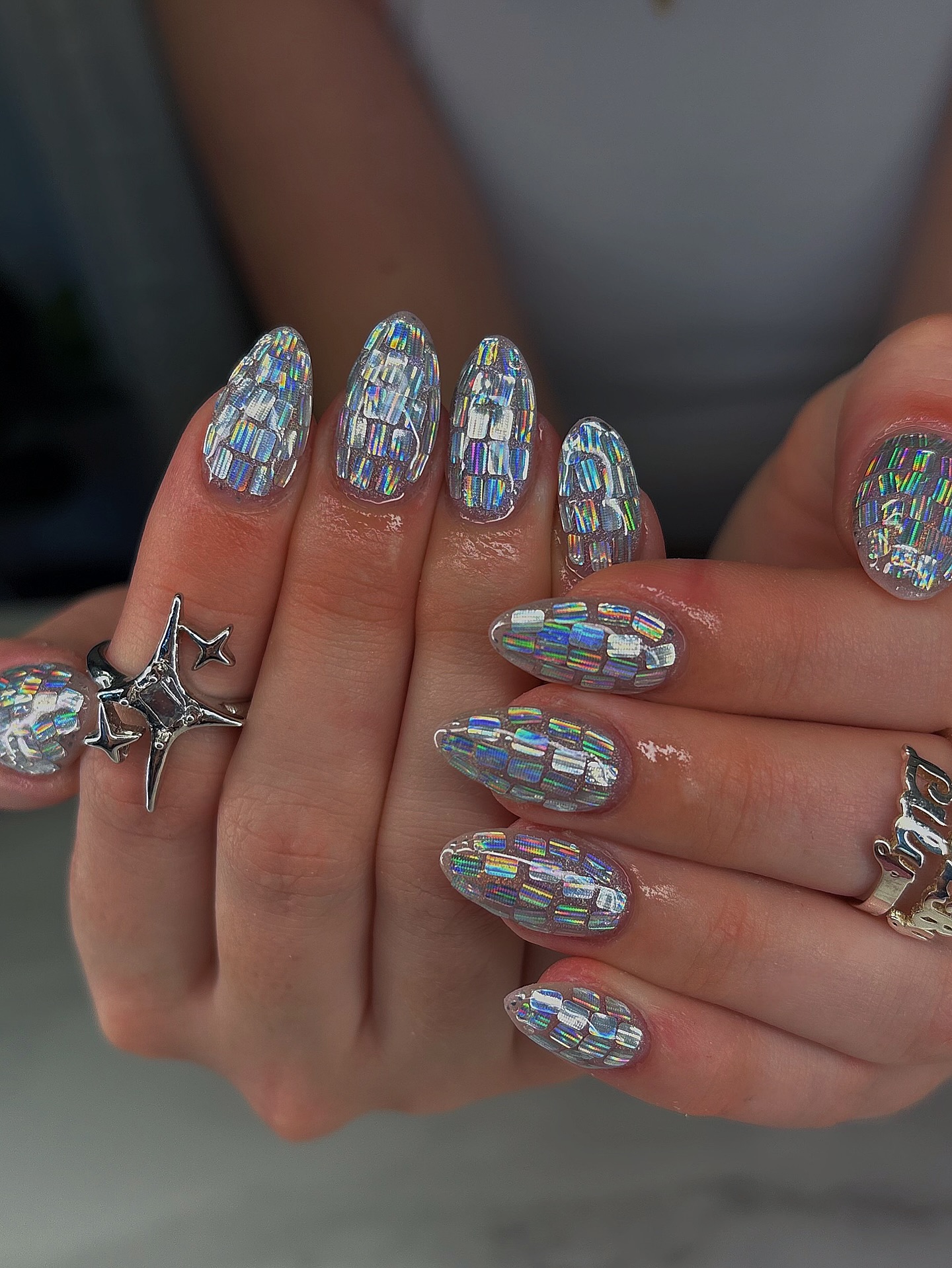 Almond nails fully covered in holographic silver baguette rhinestones creating a dazzling mosaic