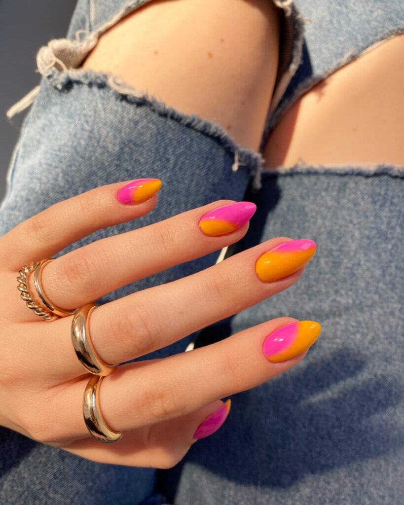 Almond nails with a bold hot pink and orange colour block ombre design