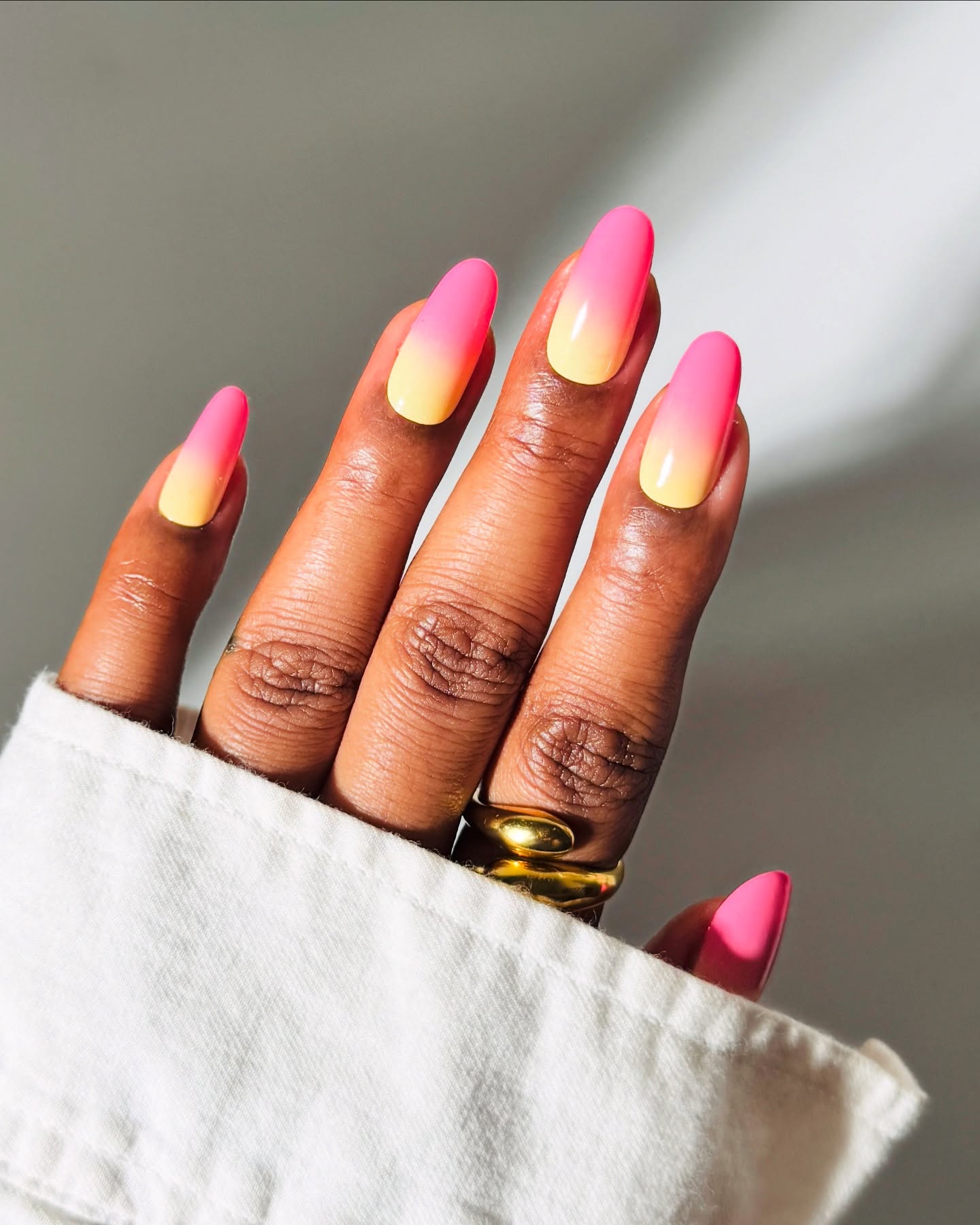 Long almond nails with a vivid hot pink to creamy yellow summer ombre gradient