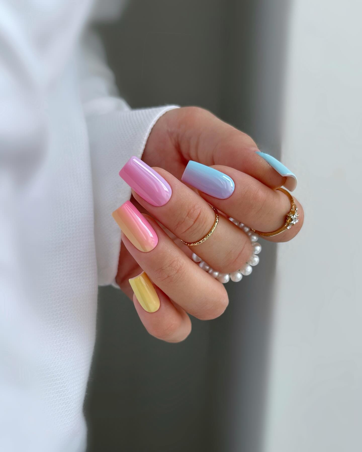 Short round nails with a hot pink to yellow sunset ombre gradient