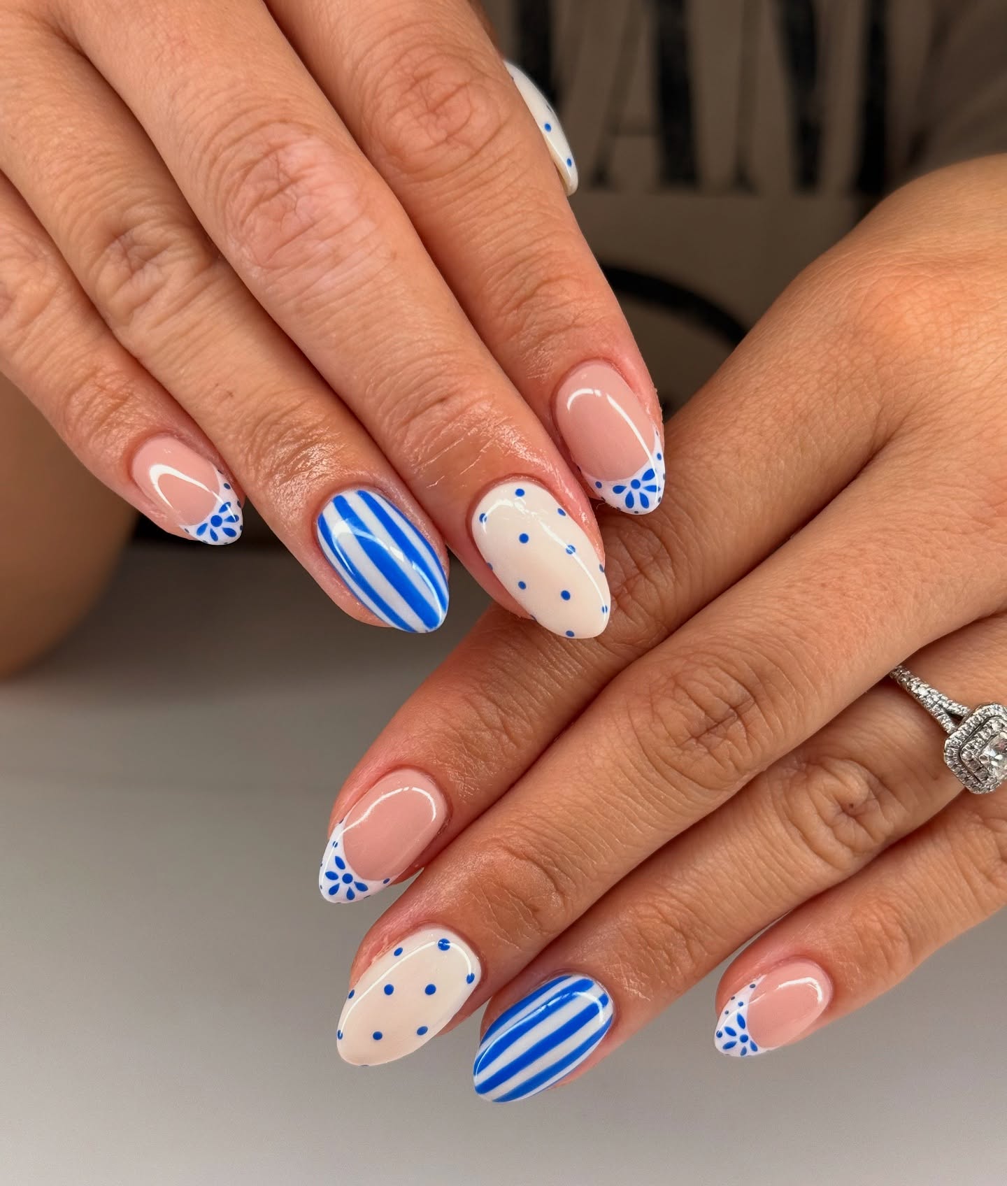 French tip nails with mixed blue stripes, dots, and florals