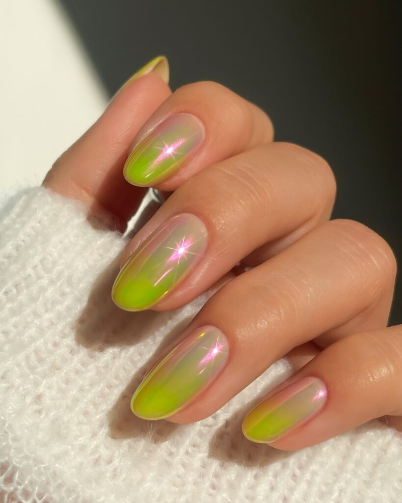 Short almond nails with a neon lime green aurora ombre fading to sheer, with pink light flare sparkle