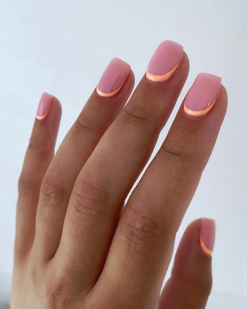 Short square nails with a neon peach-orange micro crescent French tip on a warm pink base
