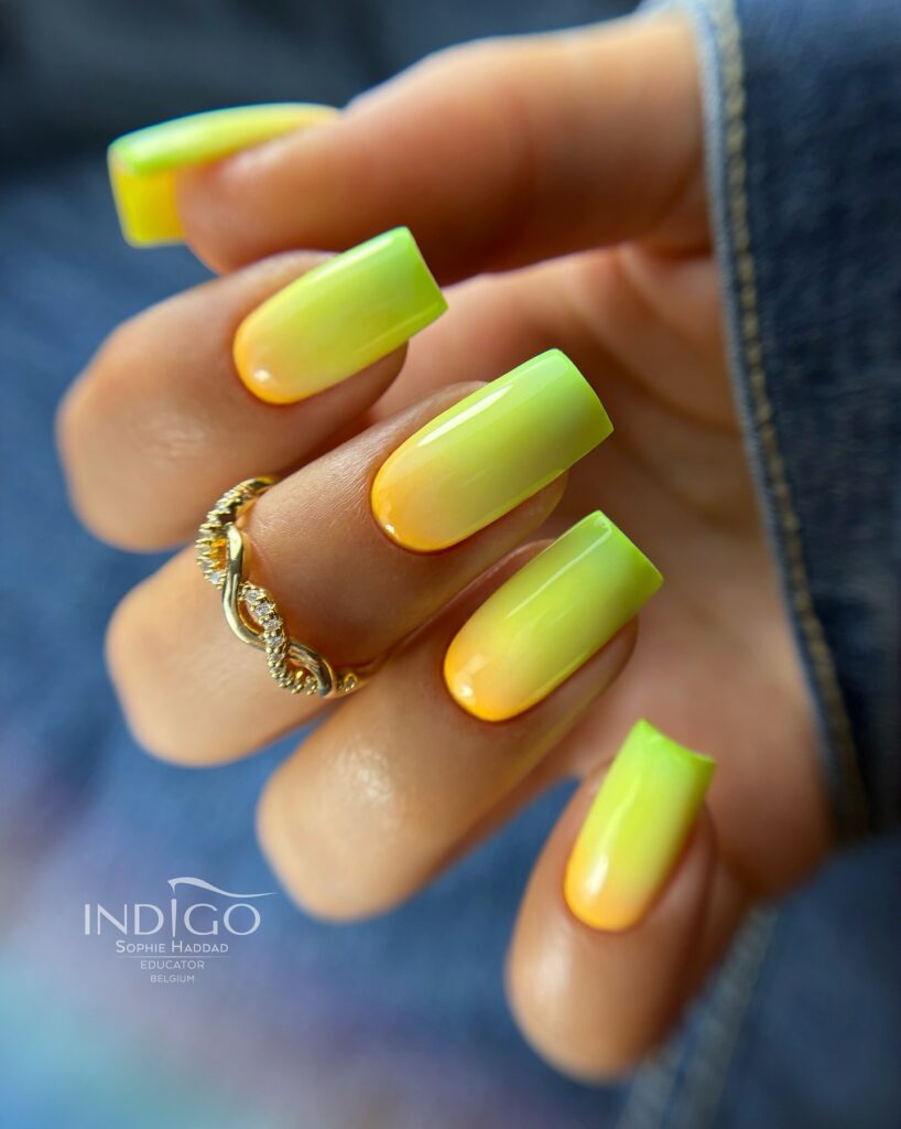 Long square nails with a neon yellow to lime green ombre gradient and high gloss finish