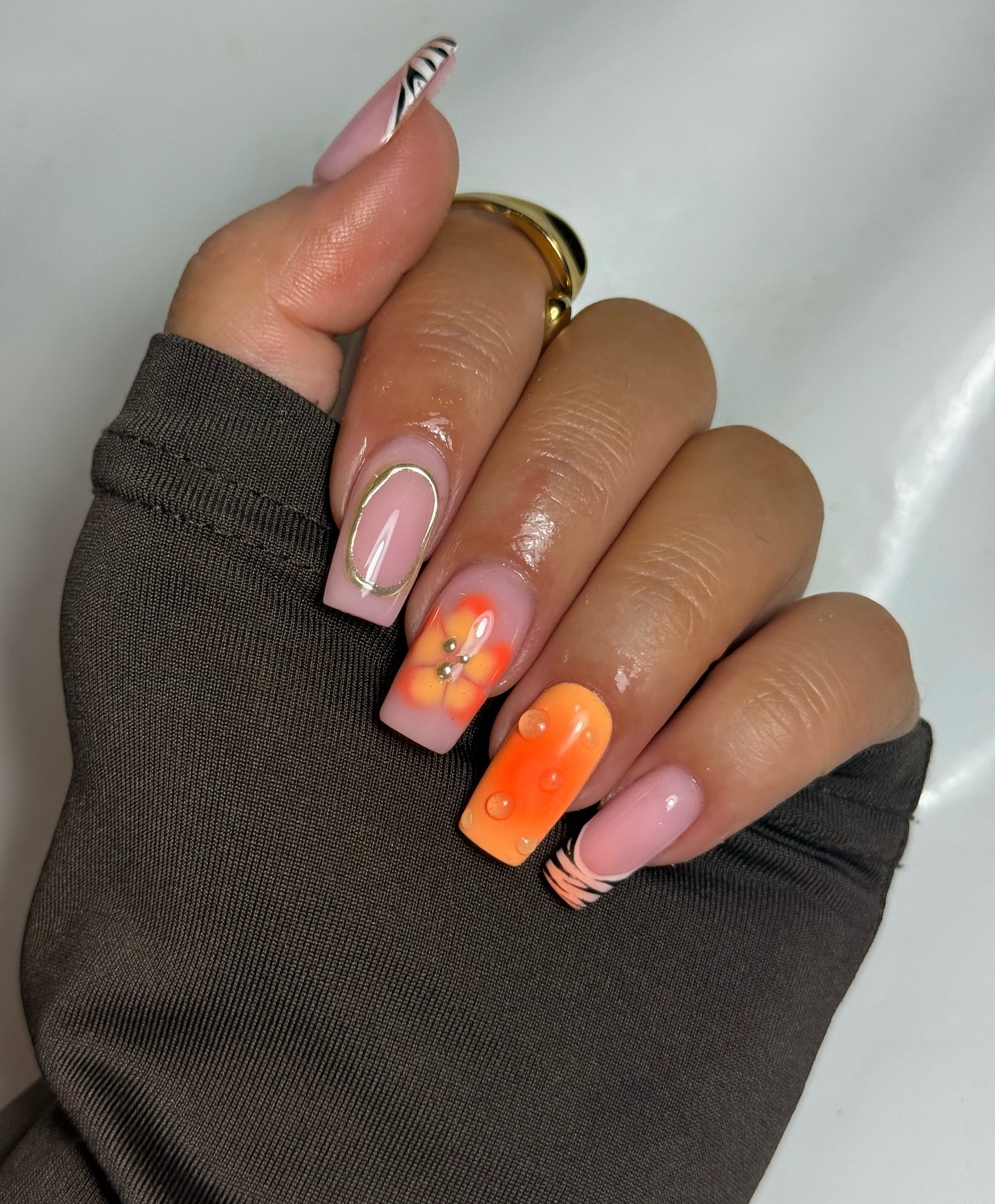 Coffin nails with solid orange, peach floral gem, zebra stripe and line art