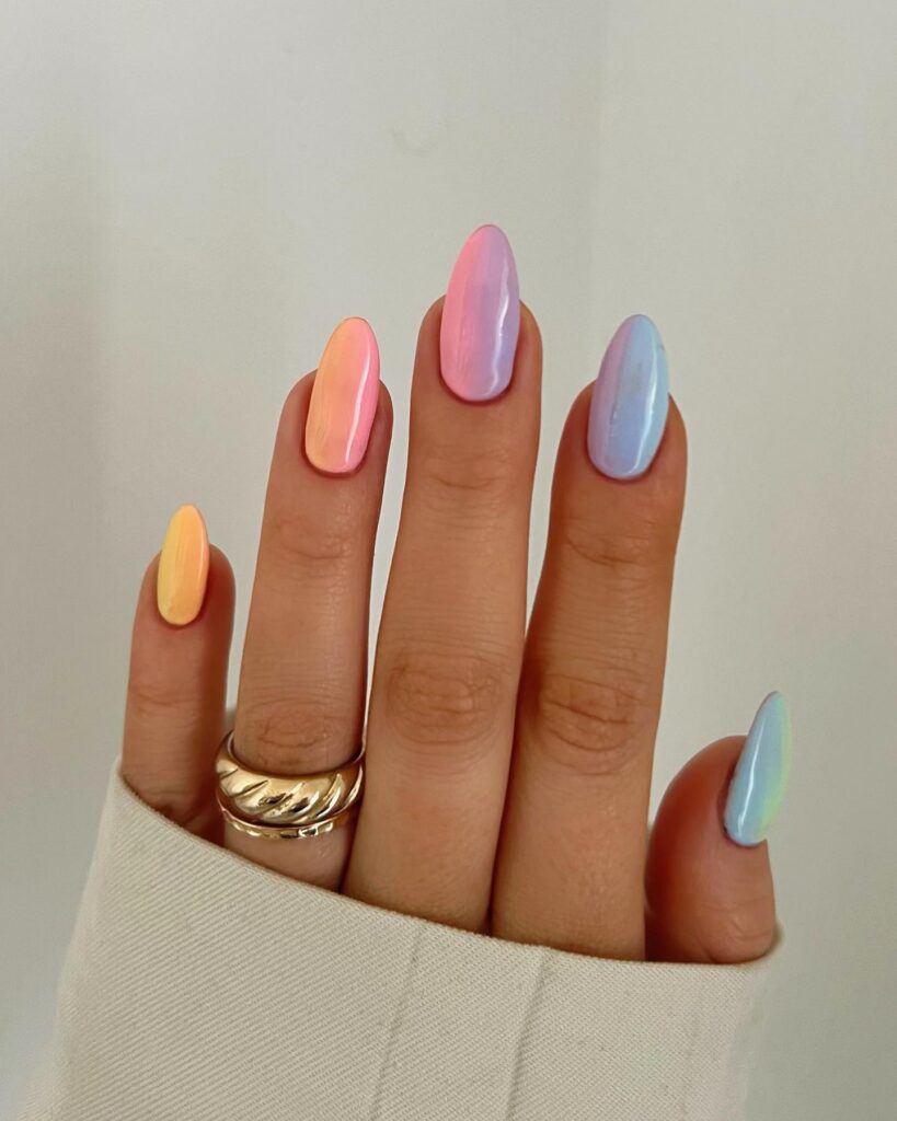 Short almond nails each wearing a different pastel aurora ombre from yellow to orange to pink to lavender to blue