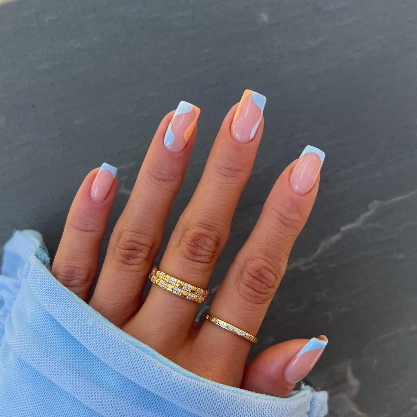 Dual-tone French tips alternating between soft peach and pale baby blue