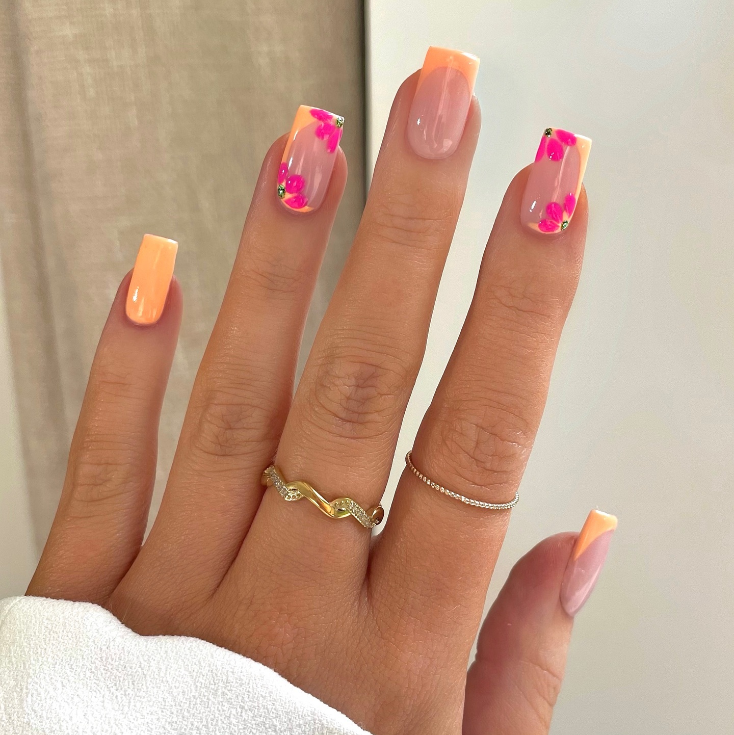 Warm peach tips with hand-painted hot pink flowers on a sheer base