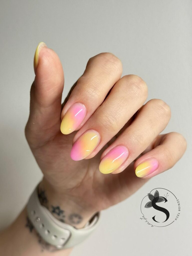 Short almond nails with a soft pink to yellow pastel ombre gradient