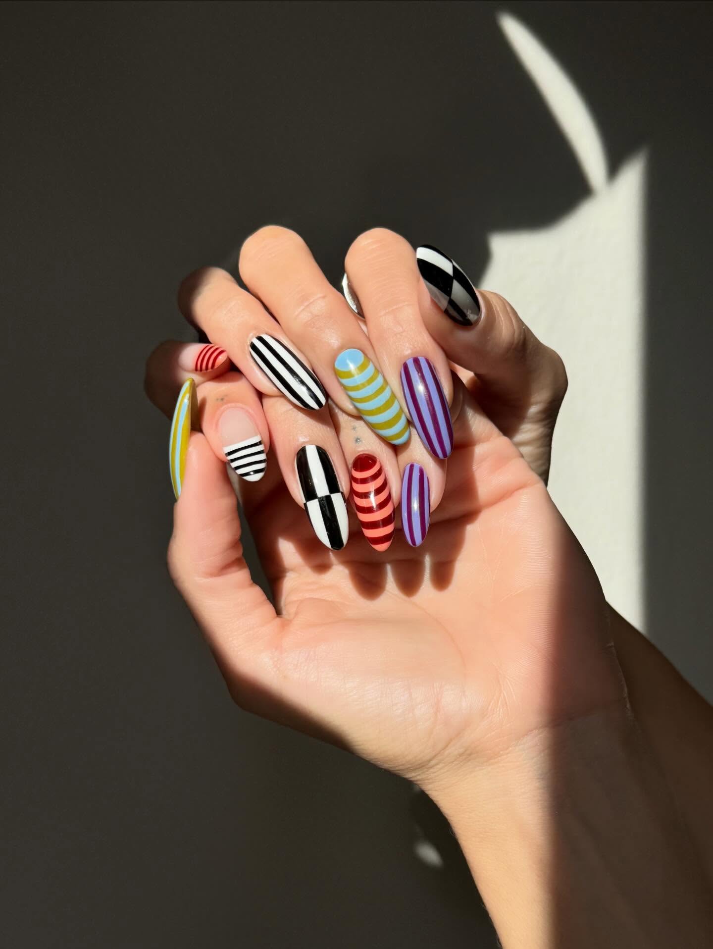 Maximalist almond nails each painted in a different coloured stripe