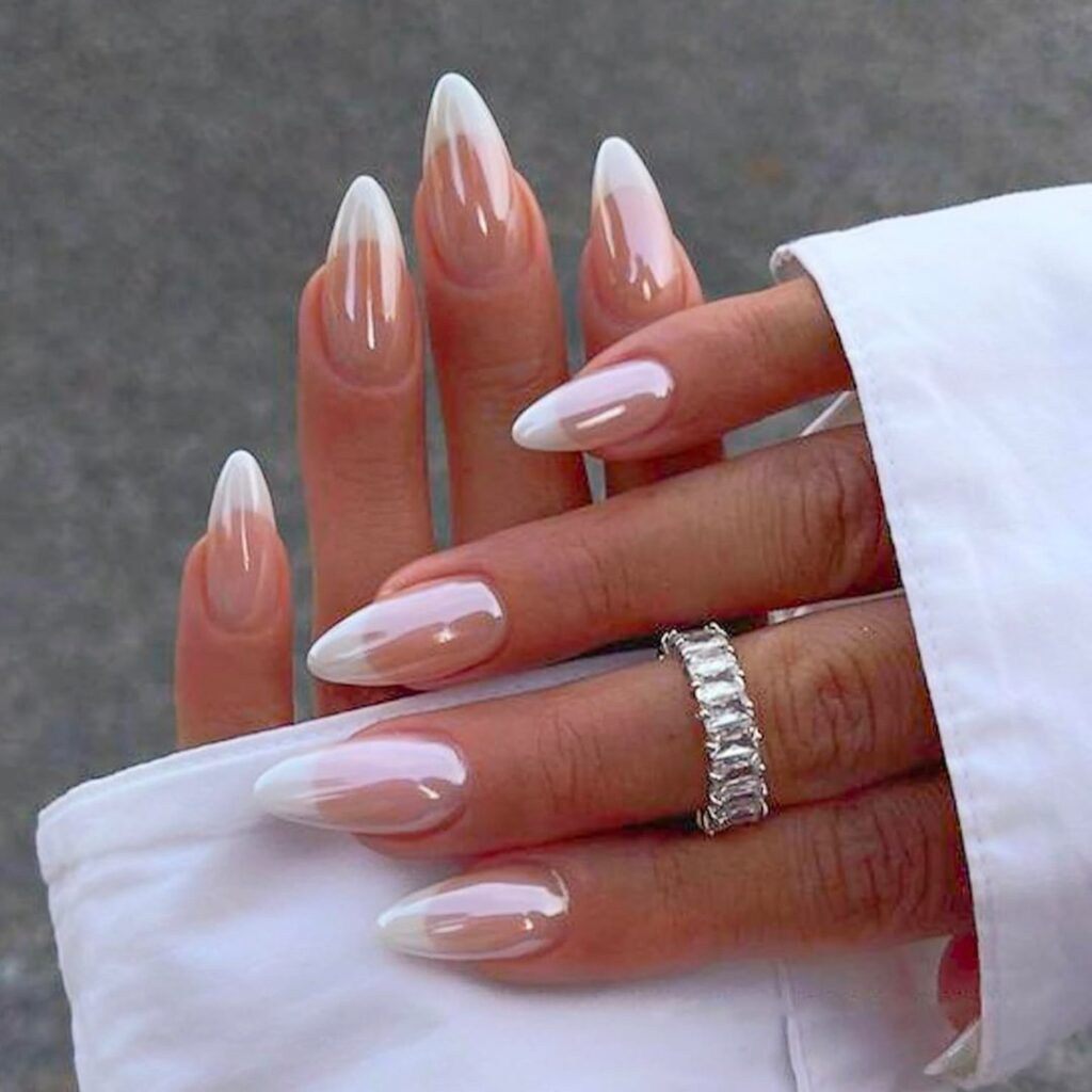 Long oval nails with a soft white-to-nude ombre fade on a warm pink base