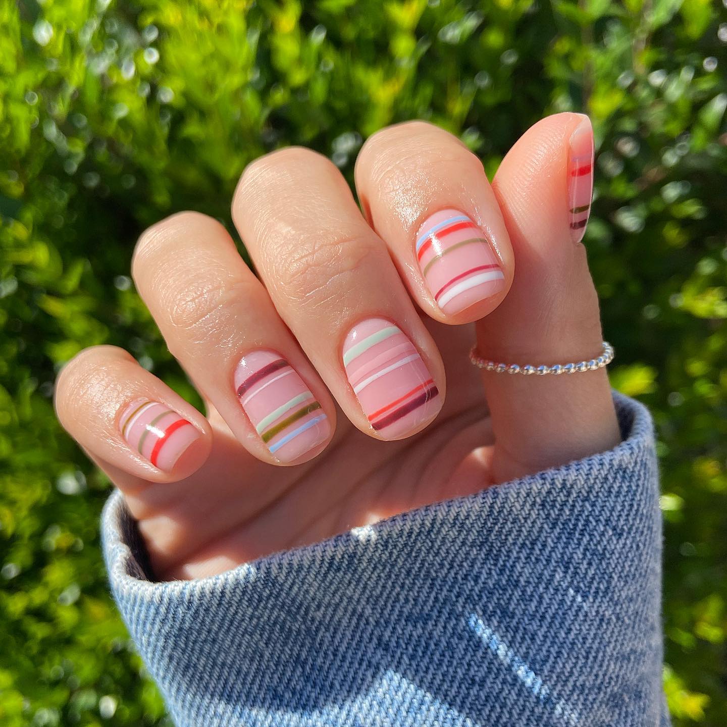 Short square nails with soft pink and coral horizontal stripes