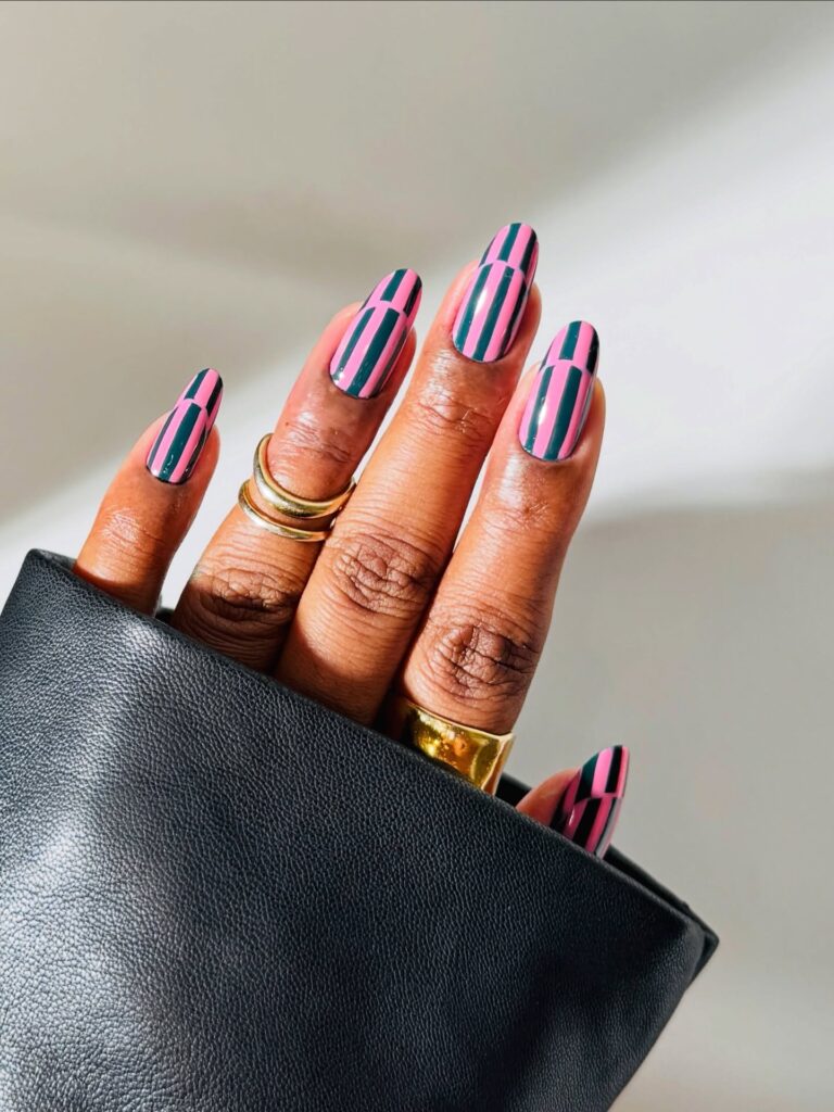 oval-shaped nails featuring a vertical pink and dark green striped pattern