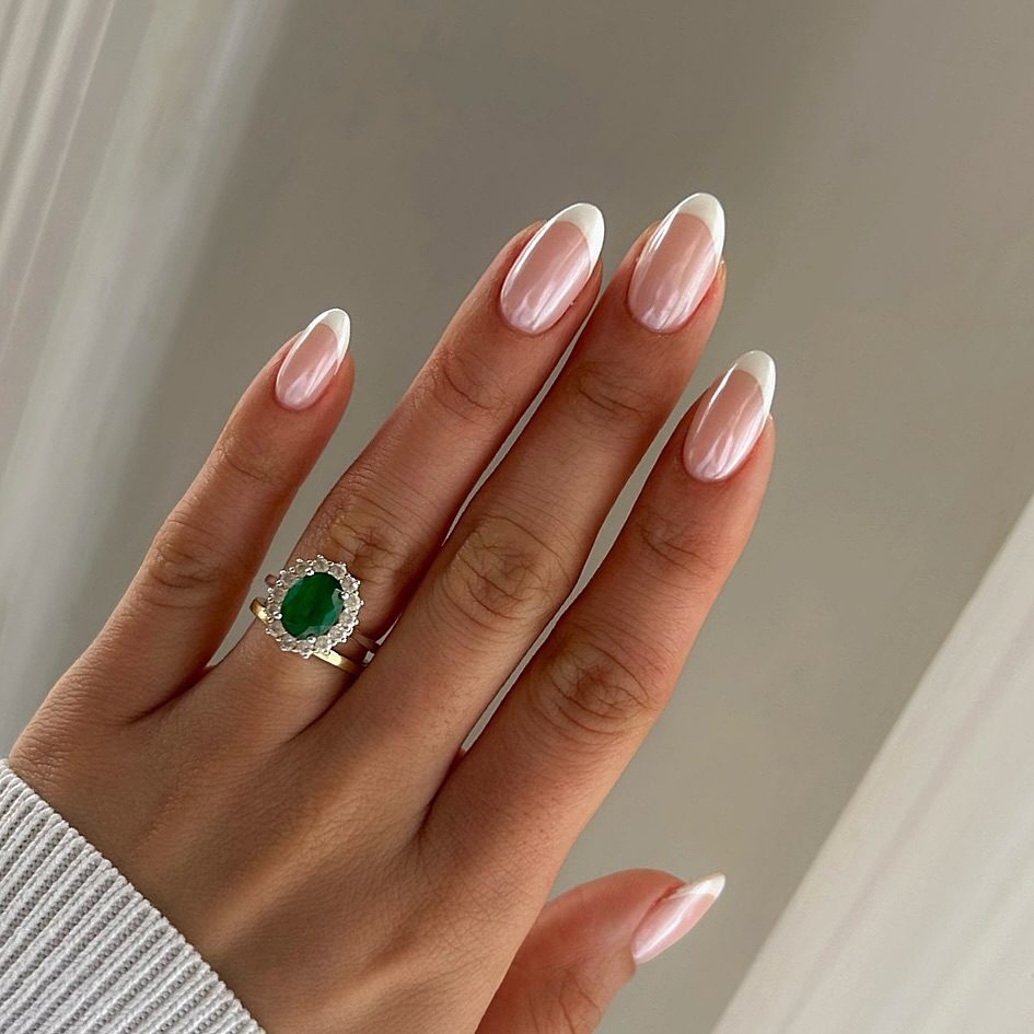 Medium oval nails with a classic clean white tip and soft pearl shimmer base