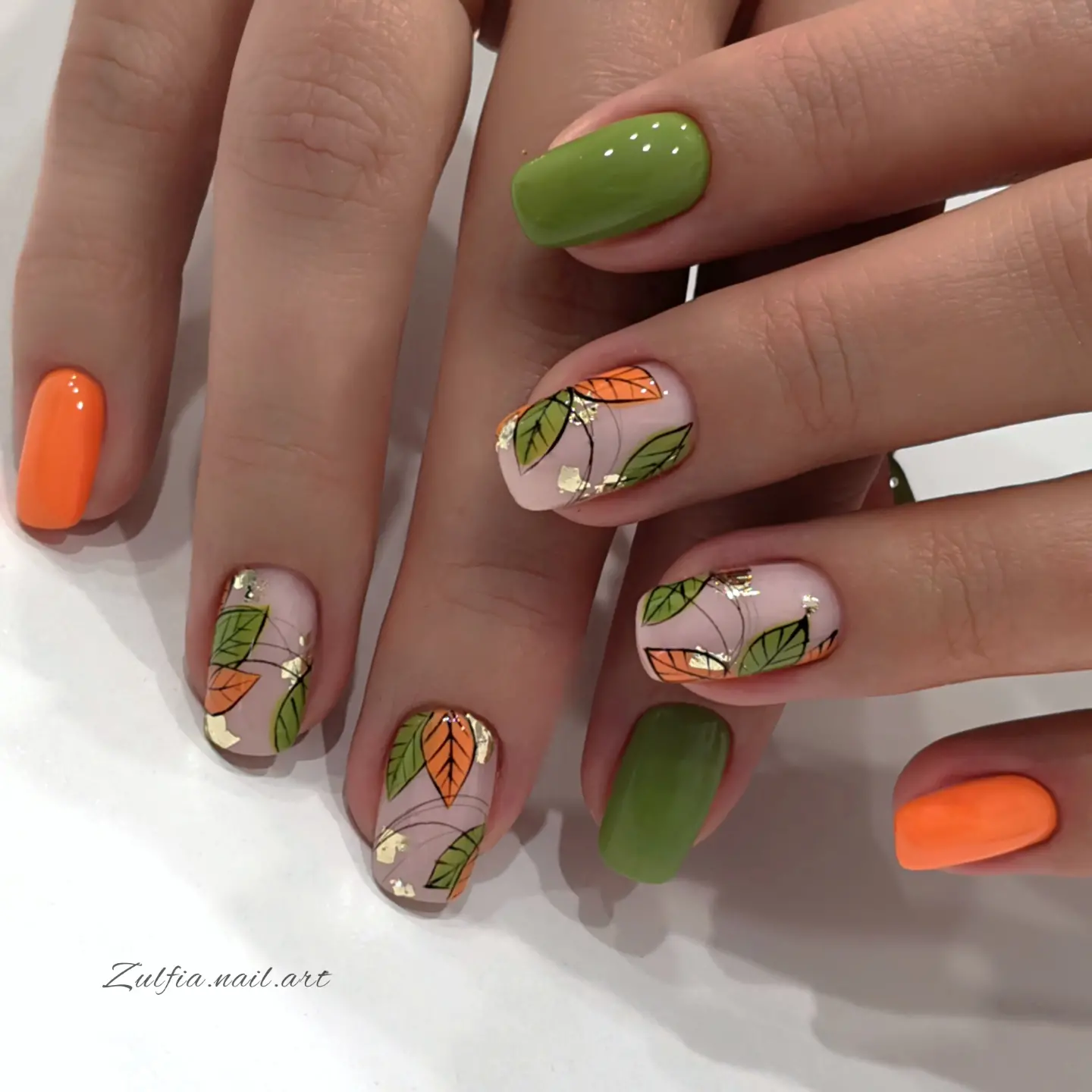 Olive and orange nails with illustrated autumn leaves