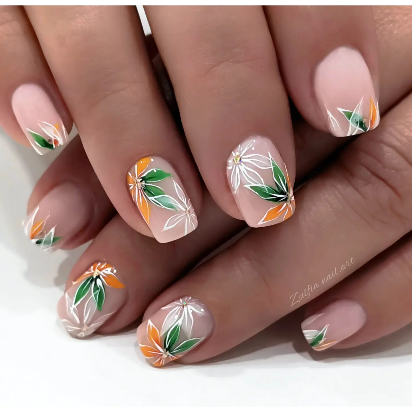 Sheer nude almond nails with green and orange leaves