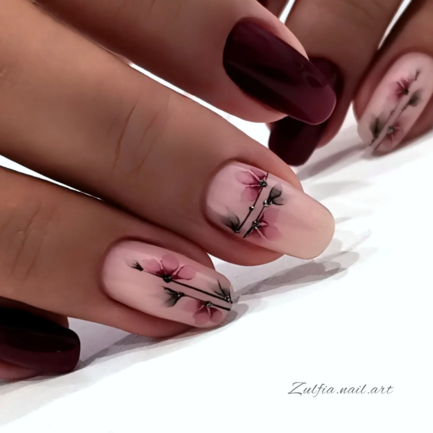 Nude and burgundy almond nails with branch details