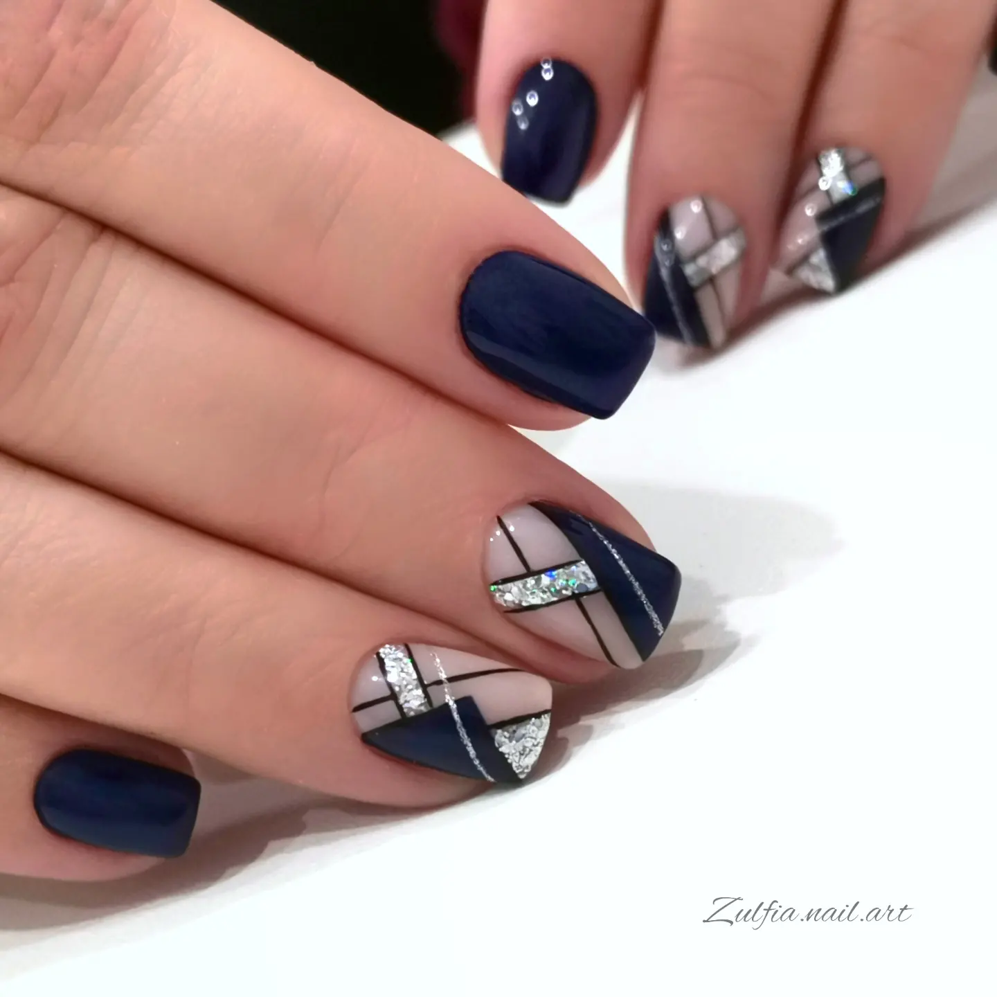 Navy blue almond nails with silver geometric accents