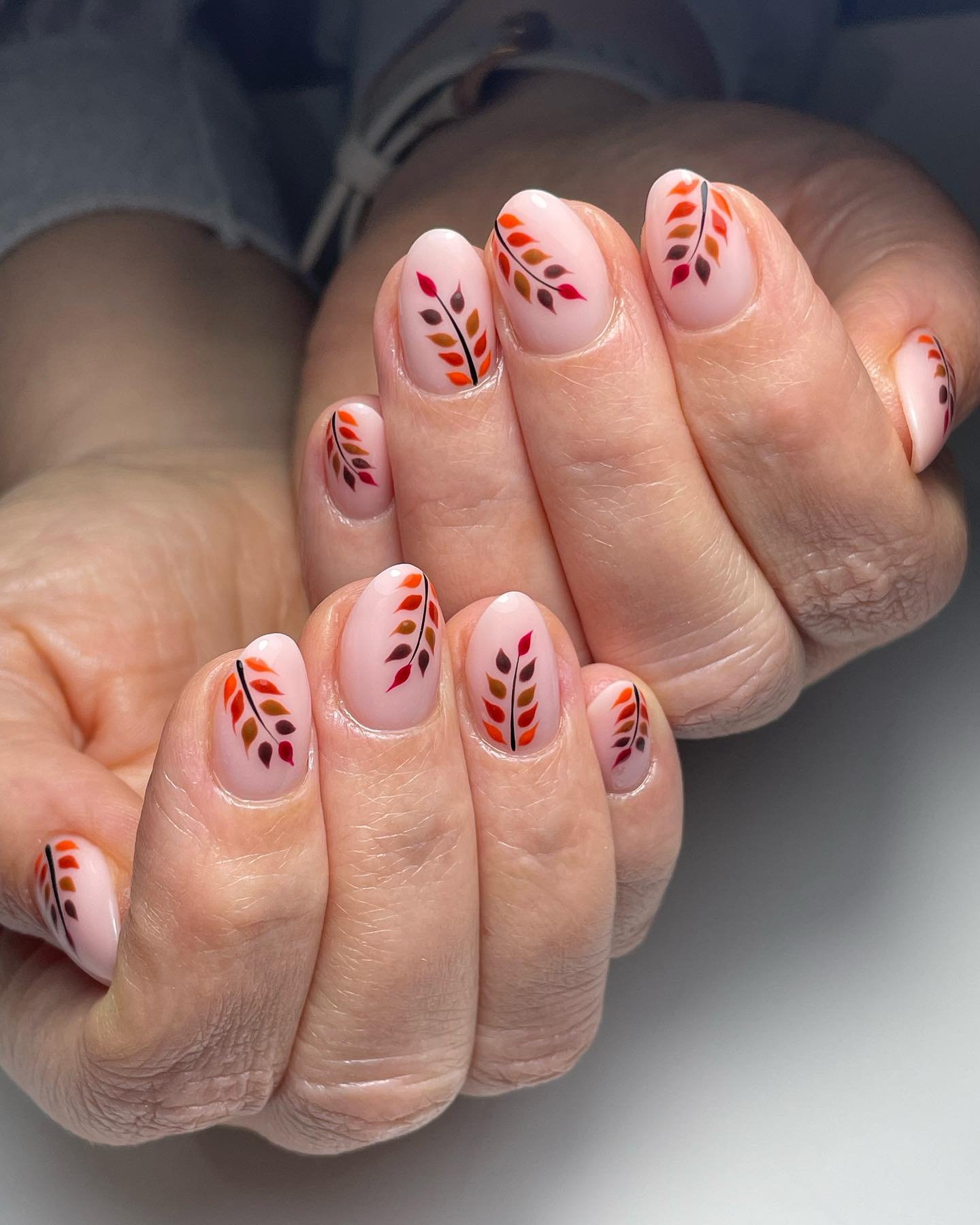 Short pink nails with tiny red decorative details