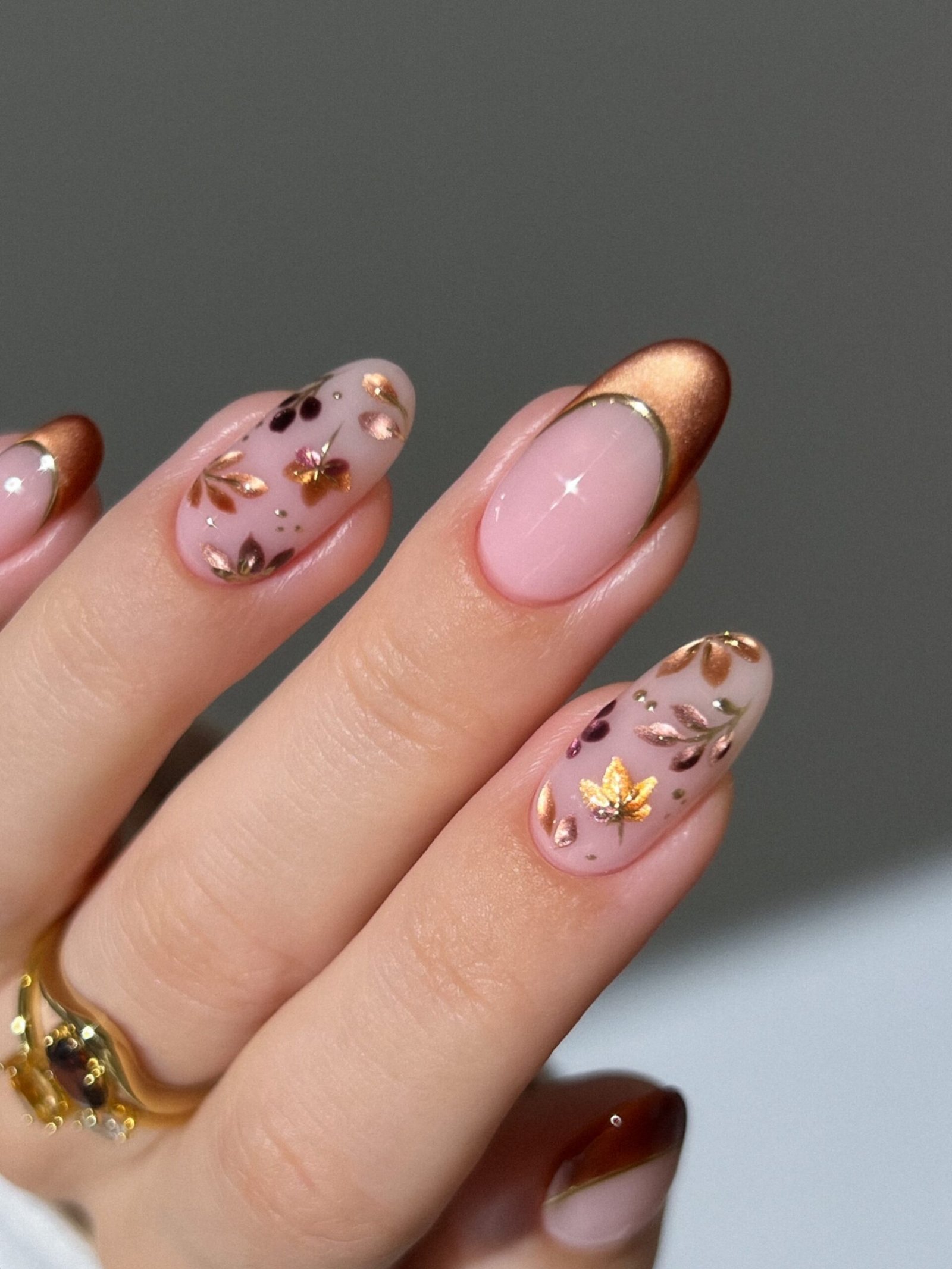 Pink almond nails with gold floral accents