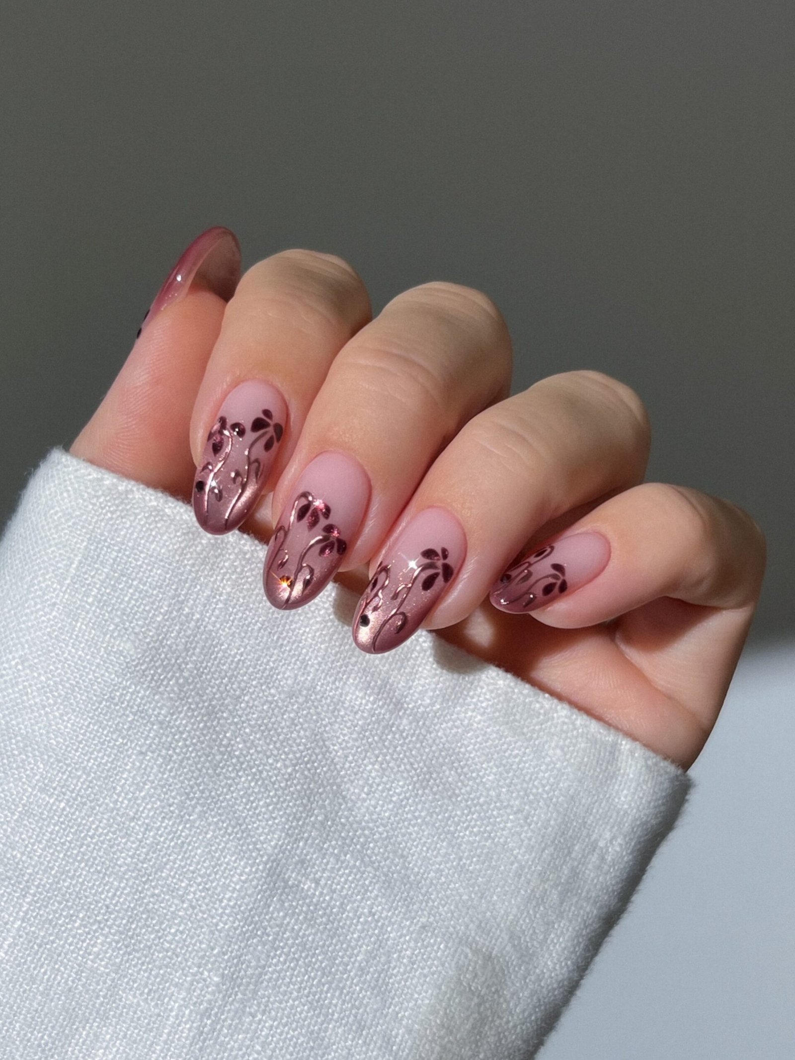 Blush almond nails with delicate botanical details
