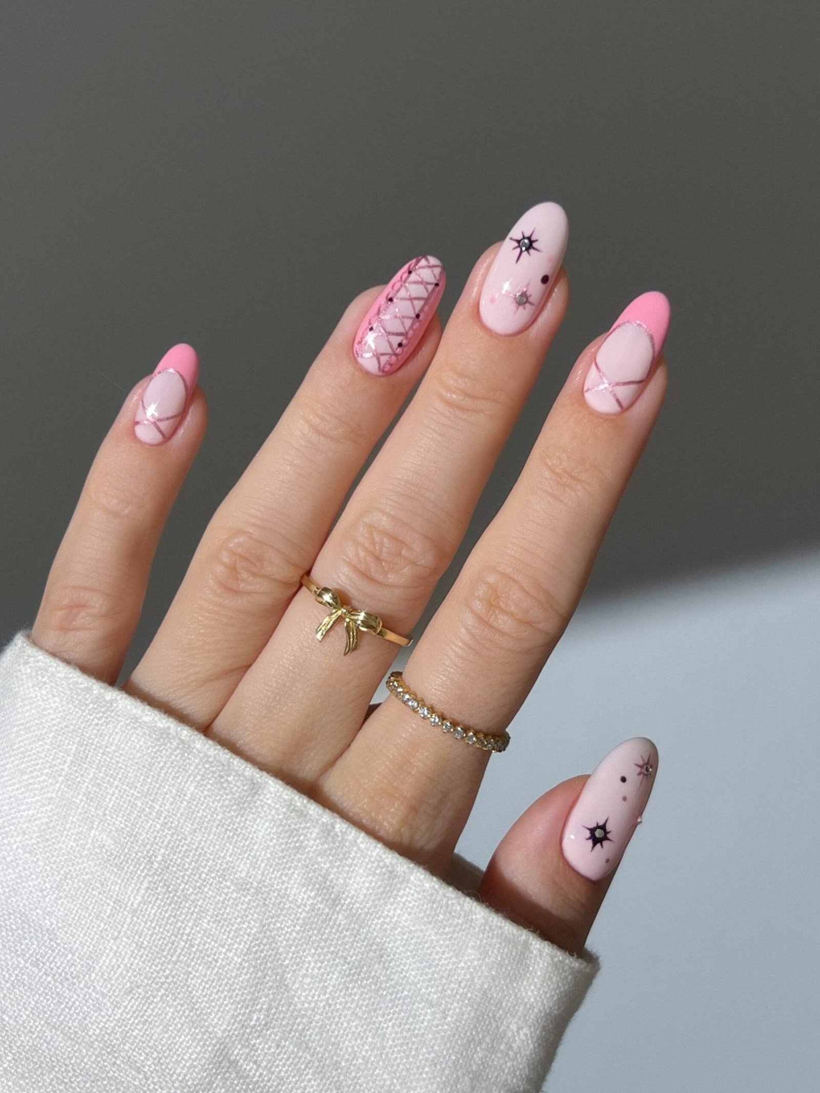 Soft pink almond nails with minimal red accents