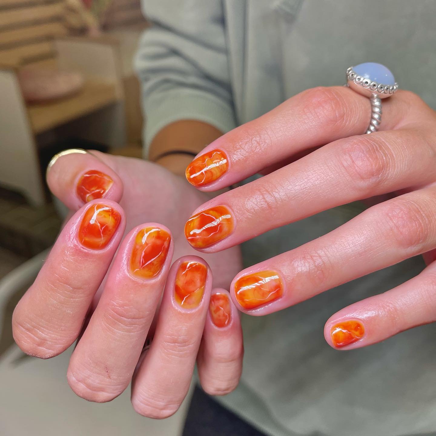 Bright Orange Glossy Nails with Autumn Swirl Accents