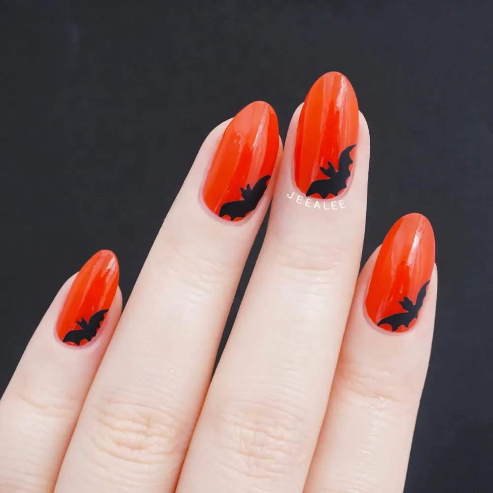 Bright Orange Nails with Black Bat Silhouettes