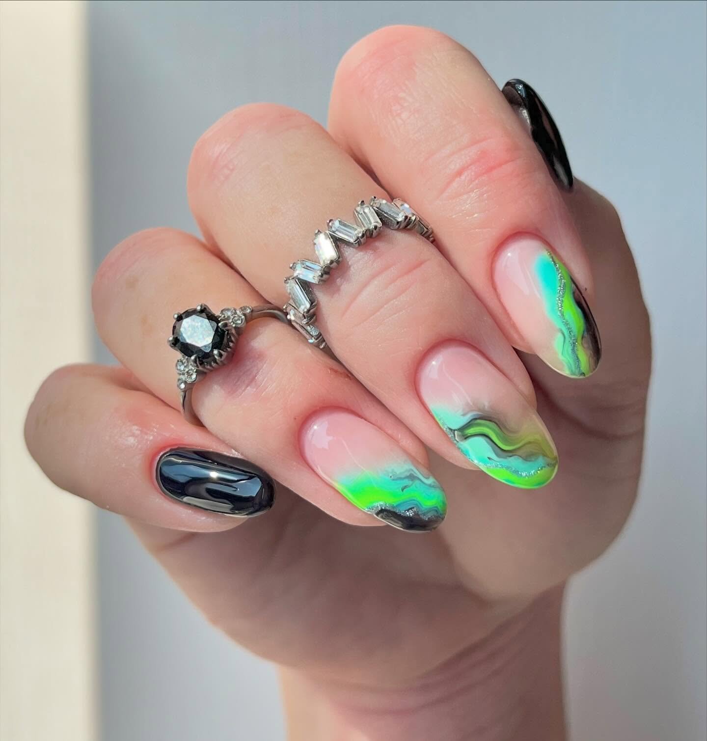 A soft sheer base is paired with neon green and black curved accents across medium-length nails