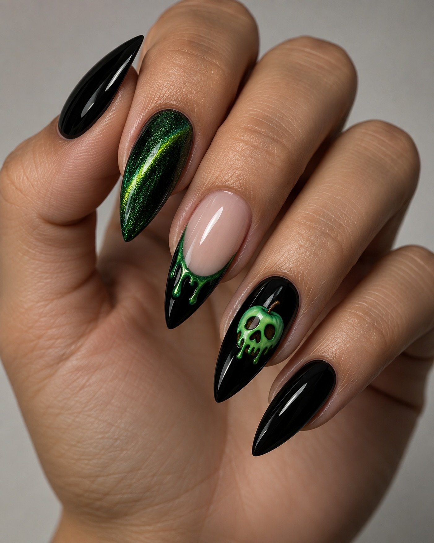 Long stiletto nails combine black and nude sections with vivid green reflective accents on selected nails