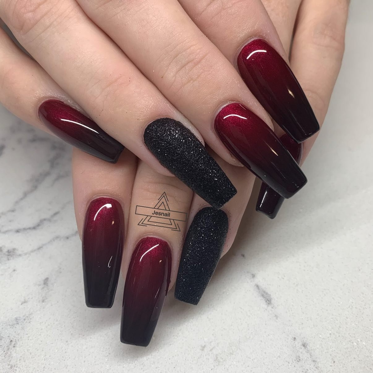 Glossy Wine Nails with a Textured Black Accent