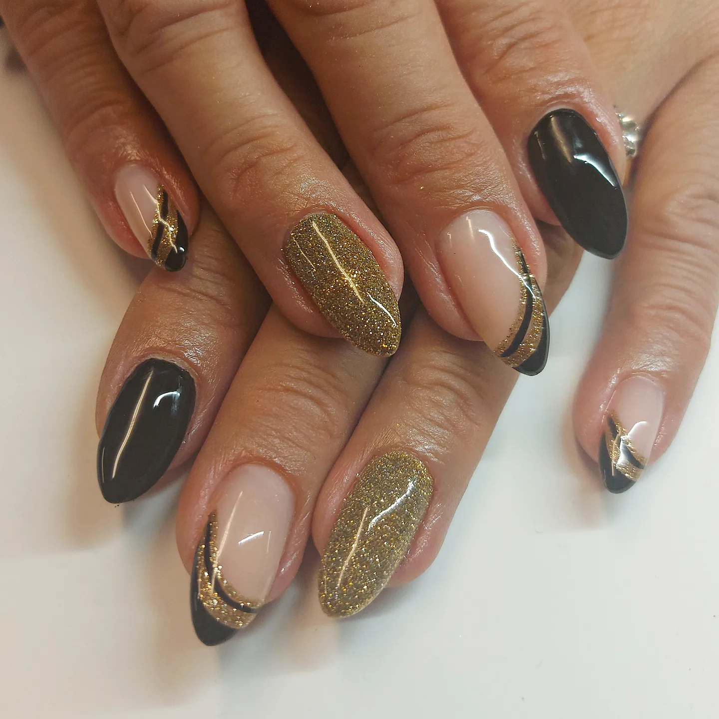 Black and Gold Almond Nails with Glitter and Outlined Accents