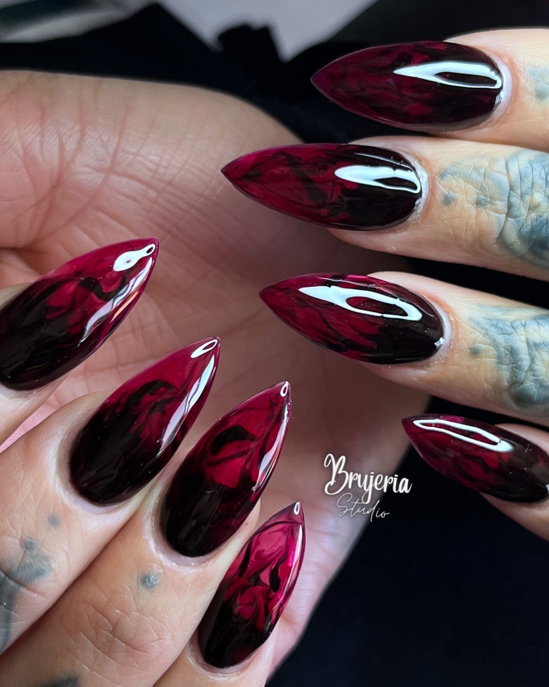 Glossy Black and Blood-Red Almond Nails with Marbled Accents