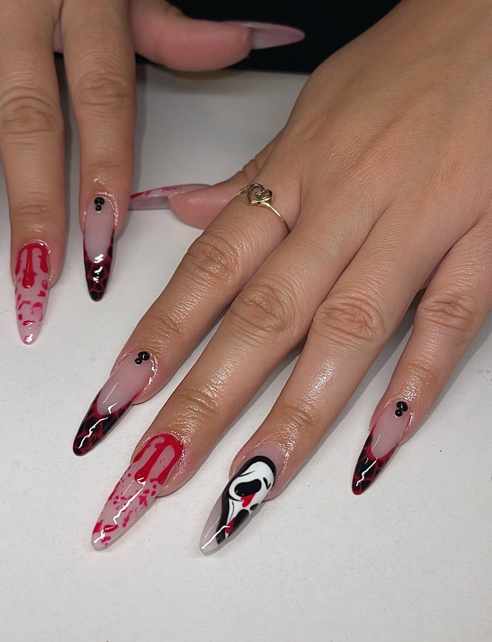Sheer Nude Stiletto Nails with Red, Black, and White Accents